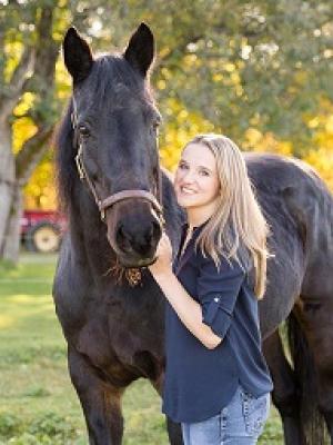 Stacy Eastman standing next to a horse.
